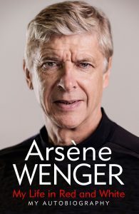 The cover of Arsène Wenger's autobiography, titled 'My Life in Red and White', featuring a head and shoulders photo of Wenger, a tall thin man with medium length grey hair dressed in a dark shirt.