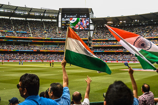Indian fans wave fans watching the cricket