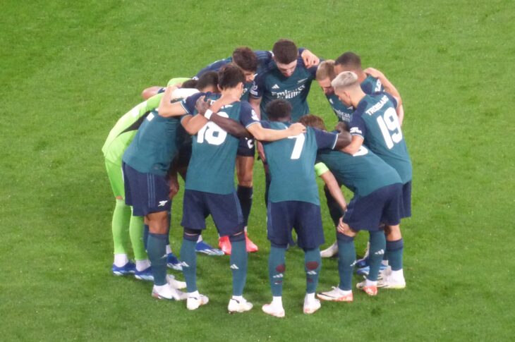 Arsenal gather in a team huddle ahead of UCL clash against RC Lens. They don their green third strip.
