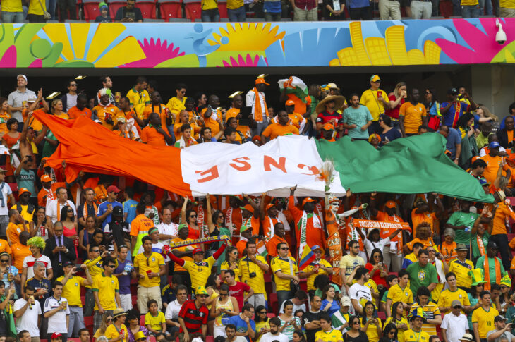 Ivory Coast fans lift a giant Ivory Coast flag in the stands at the 2014 World Cup