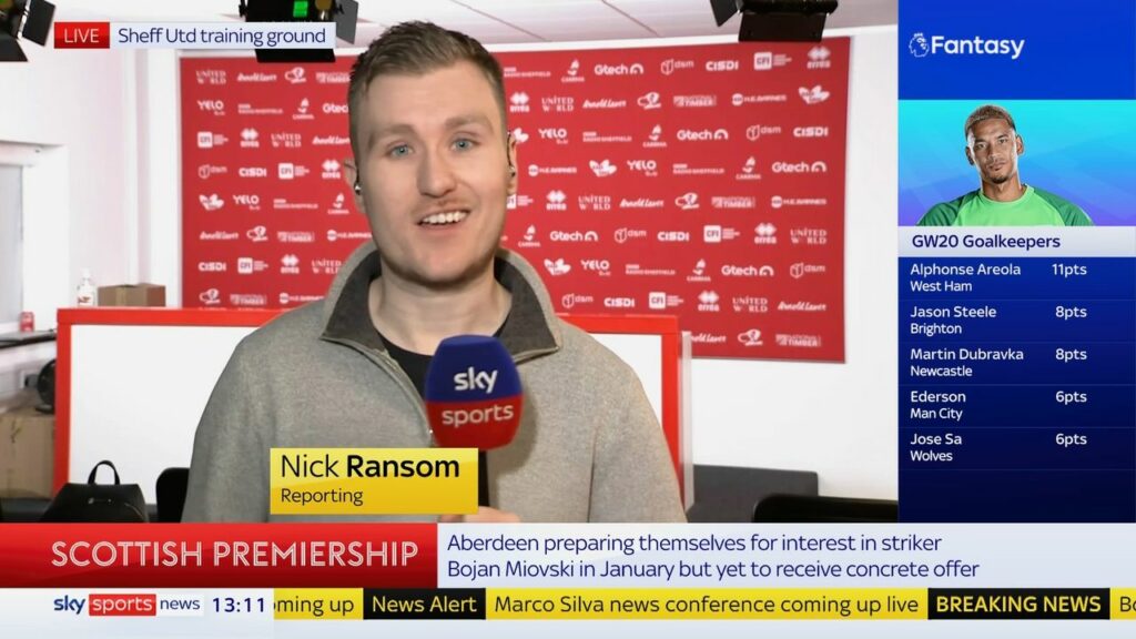 Nick Ransom presentign on Sky Sports News holding a Sky Sports microphone.