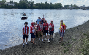 The crew disembarks on the shores by Kew Bridge